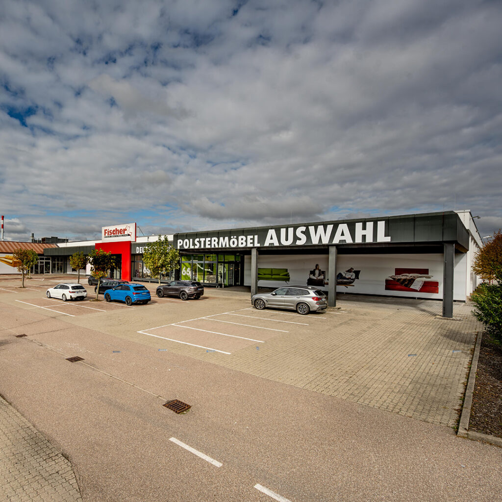 Panoramablick auf die Polstermöbel Fischer Filiale in Bruchsal mit großzügigem Parkplatz und großer Auswahl an Sofas, Sesseln und Boxspringbetten.