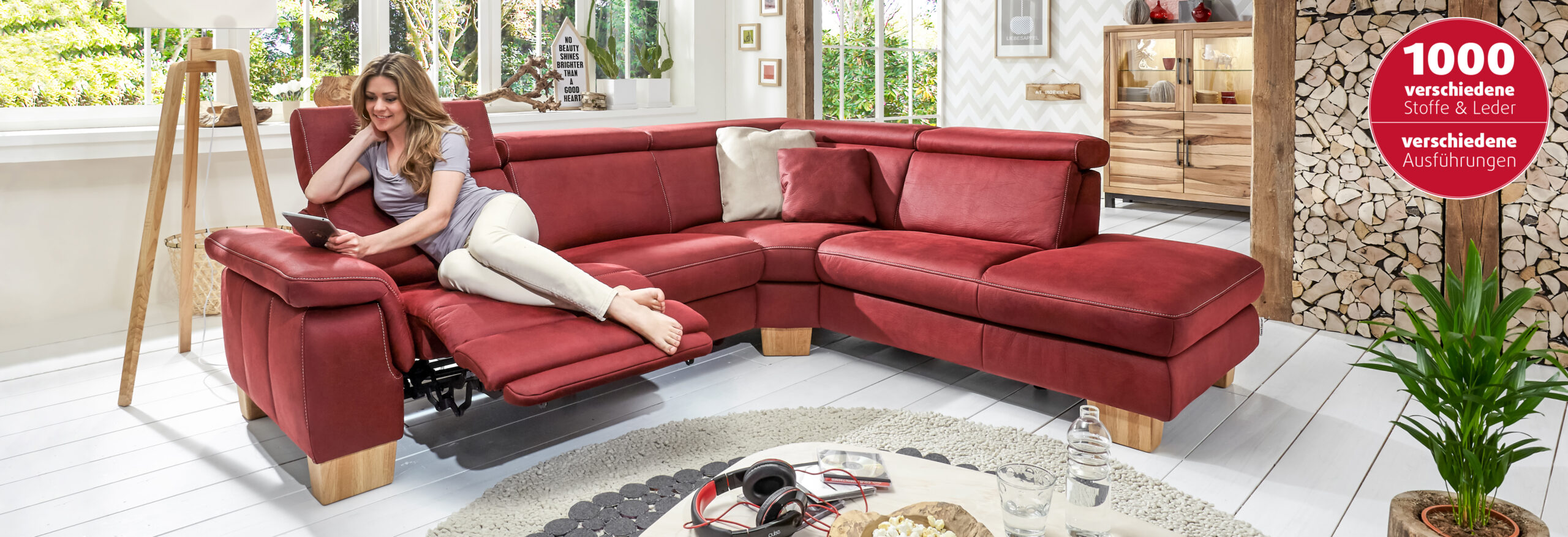 Eine Frau entspannt auf einem roten Ledersofa.