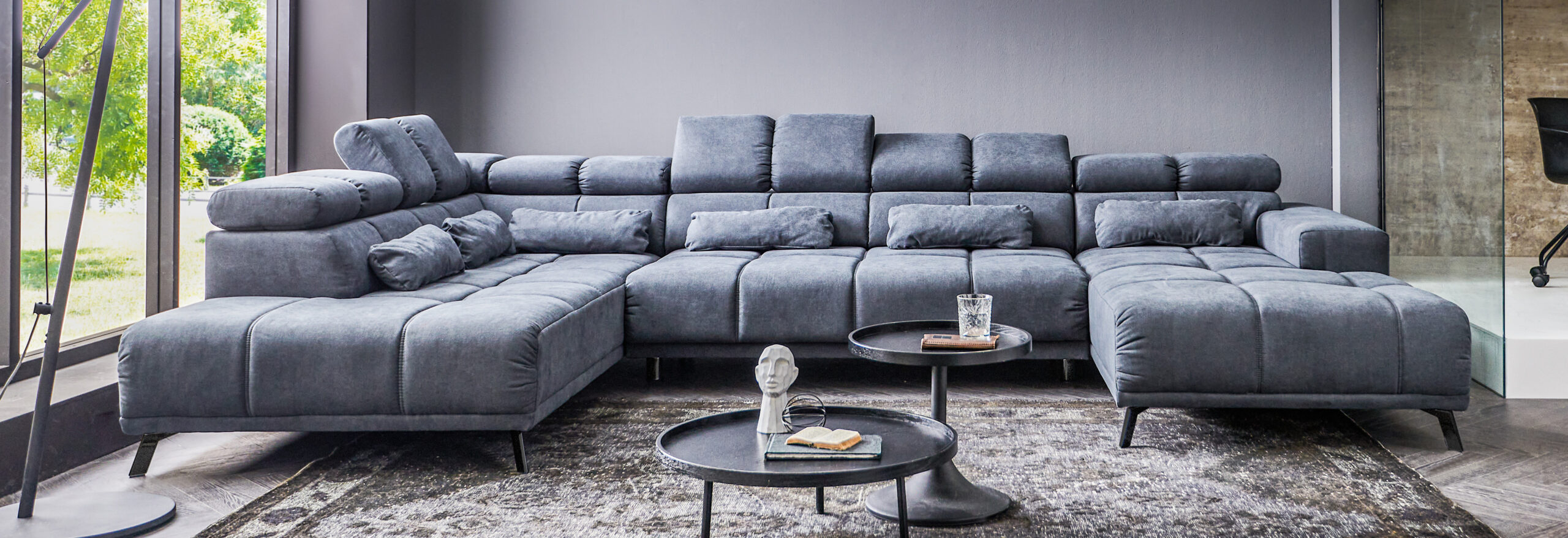 Modernes Wohnzimmer mit großer grauer Couch.