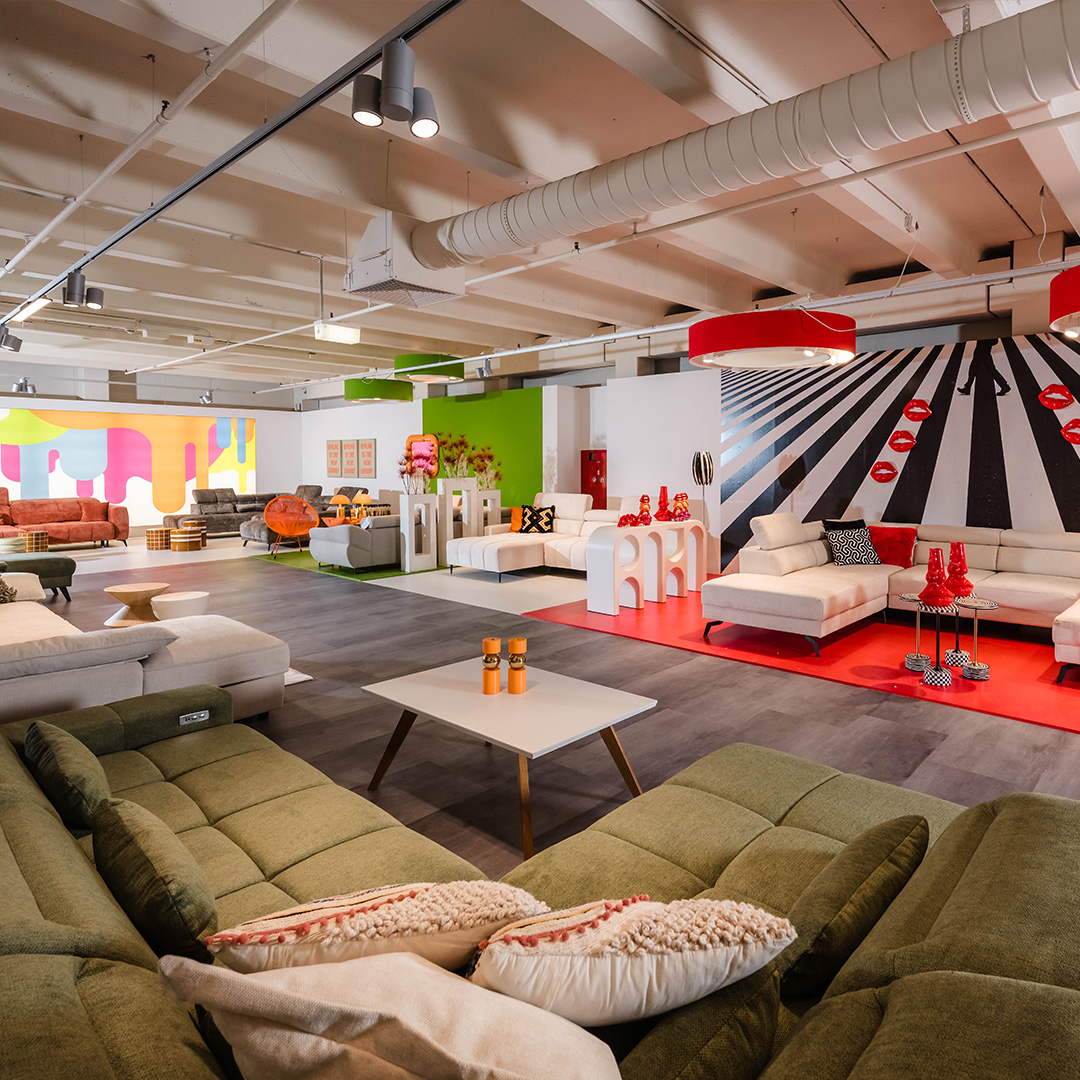 Moderne Sofa-Ausstellung bei Polstermöbel Fischer Nürnberg mit farbigen Wohnlandschaften, Designsofas und kreativer Wandgestaltung.