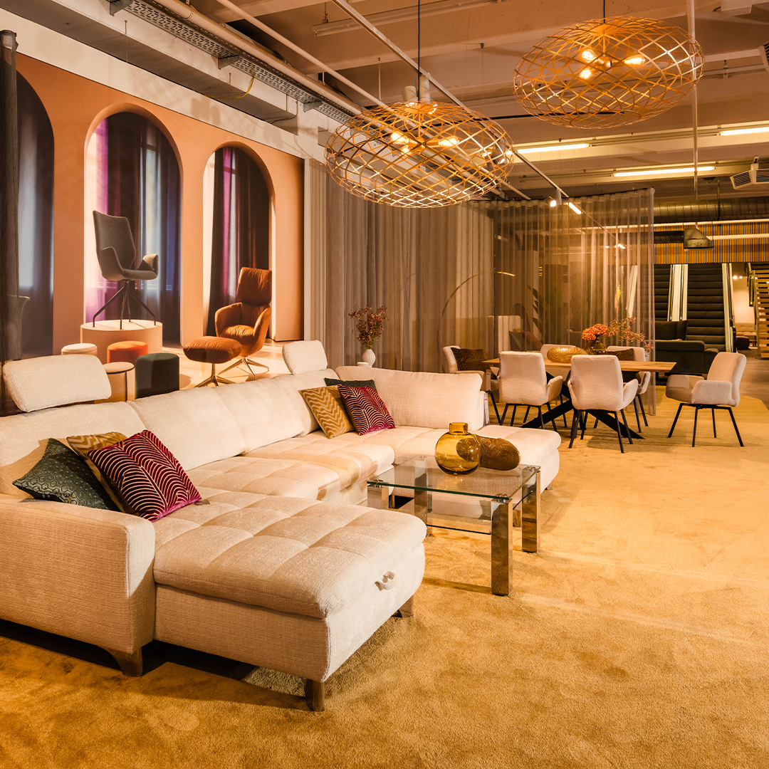 Wohnliche Sofa-Ausstellung bei Polstermöbel Fischer Nürnberg mit Stoffsofa, Couchtisch und Essbereich im Möbelhaus.