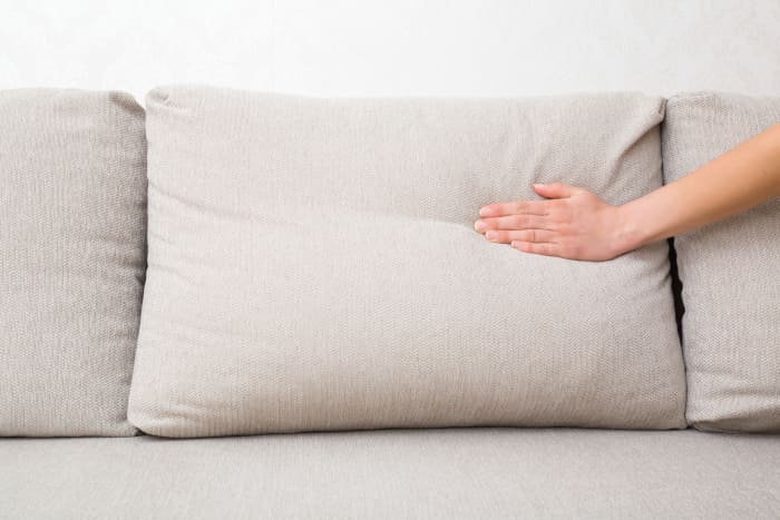 Hand liegt auf Sofapolster