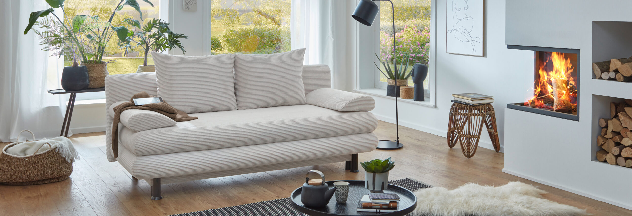 Schlafsofa in Cord steht in einem modernen Wohnzimmer