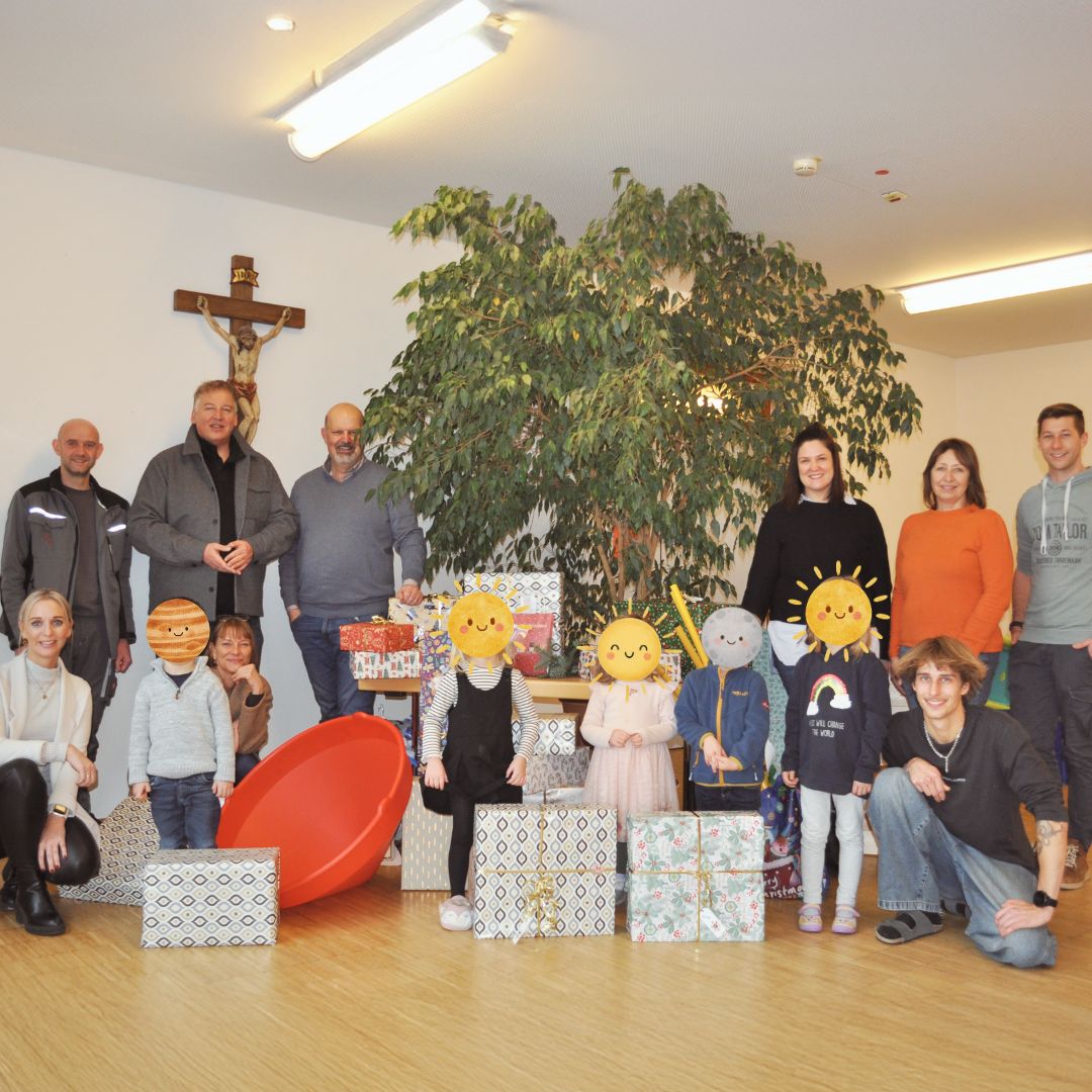 Gemeinsames Gruppenfoto bei der Spendenübergabe von Polstermöbel Fischer an eine soziale Einrichtung mit Kindern und Weihnachtsgeschenken